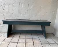 Front view of green wooden bench showing top, legs, and stretcher
