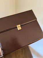 Front flap of brown leather organizer showing gold-tone clasp