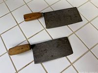 Both cleavers full view on tiled surface