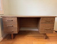 Front view of wooden executive desk showing six drawers and legs