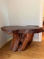 Front view of live edge burl wood coffee table showing root base and slab top