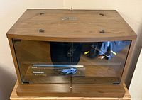 Sony wood laminate stand with smoked glass doors, showing interior shelf