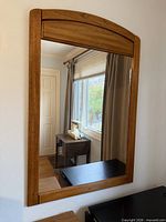 Front view showing full mirror with wooden frame and arched top