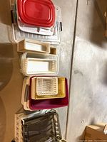 full group of assorted plastic storage pieces laid on floor