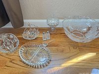 Group shot of all clear etched and pressed glass pieces laid out on floor