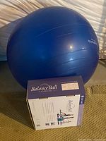Blue balance ball next to Gaiam Balance Ball Fitness Kit box