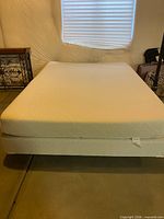 Top view of white mattress and box spring on metal frame