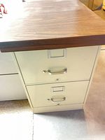 Front view of beige 2-drawer filing pedestal showing handles and label frames