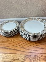 Stacked dinner and salad plates showing striped rims