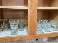 Cabinet view showing all goblets and sherbet dishes lined on shelf