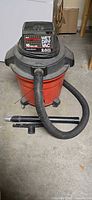 Full view of one Craftsman red 16-gallon wet/dry vacuum with hose and attachments