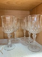Five crystal wine glasses on shelf