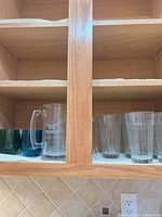 Cabinet shelf showing beer mug and ribbed tumblers