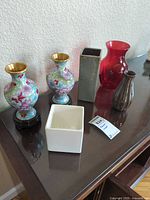All six vases displayed together on console