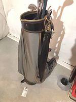 Full view of gray golf bag on cart with clubs