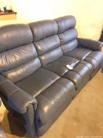 Front view of blue leather three-seat couch showing cushions and seating surfaces