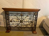 Front view of console shelf showing wood top and decorative metal front
