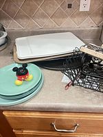 stacked trays, green plates, Mickey shaker, wire basket, napkin holder