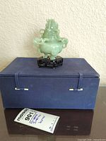 Incense burner on wood stand atop blue storage box