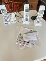 Full set showing three handsets, three charging bases, two power adapters, manuals