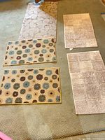All five rugs arranged together: two daisy floral, two beige textured, one scroll vine