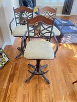 Front view of all three stools showing cushions, metal frames and wood accents
