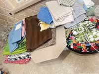 Mixed stack of placemats, towels, hot pad on counter
