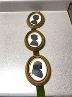 Entire trio of oval framed silhouettes connected by ribbon