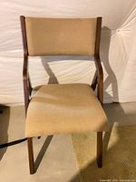 Front view of chair showing wood frame and tan upholstery
