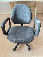 Front view of gray office chair showing seat, backrest, armrests, base with casters