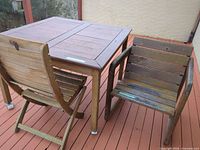 Square hardwood patio table with two chairs on deck