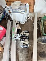 overview of rails, carriage assembly, seat parts on garage floor