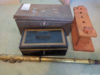 Group shot showing all four items: brass tube, two boxes, wooden block