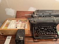 Underwood typewriter beside wooden slide box containing assorted slides and small box camera
