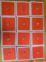 Twelve identical Canadian Centennial pins on individual red cards