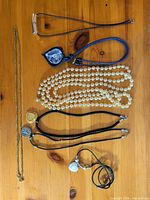 All seven necklaces laid out flat showing overall styles and pendants.