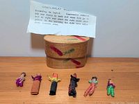 Six worry dolls, wooden box, paper label overview