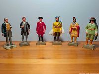 All six resin figurines lined up on wooden surface