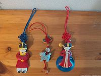 All three Chinese hanging ornaments laid out on wood surface