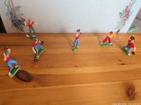 All six baseball miniatures on wooden surface