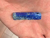 Front view of rectangular lapis lazuli bead showing drilled hole and color