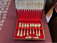 open storage chest showing knives in lid, forks, spoons in base