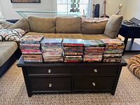 Wide view of eight stacks of DVD cases on coffee table