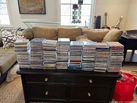 Front view of nine stacks of compact discs on coffee table