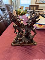 Front view of dark hardwood Balinese sculpture with two kneeling figures and ornate headdresses