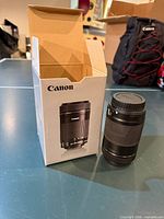 Canon EF-S 55-250mm lens beside open original box