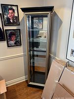 Full view of curio cabinet showing glass door, shelves and lighted top
