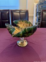 Full view of green and gold art glass bowl on pedestal