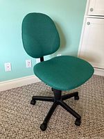 Full view of green fabric office chair, angled left
