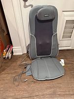 Front view of grey HoMedics massage seat cushion with attached cord